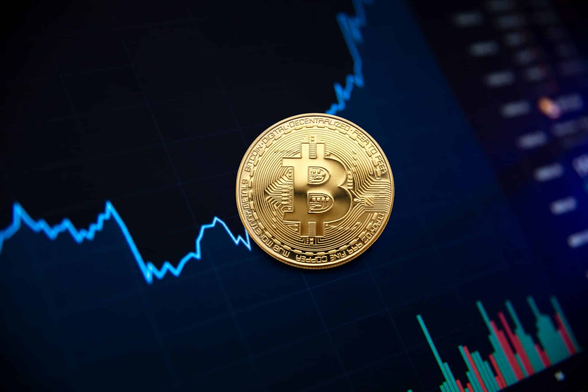 Une pièce représentant le bitcoin sur fond de courbes de trading