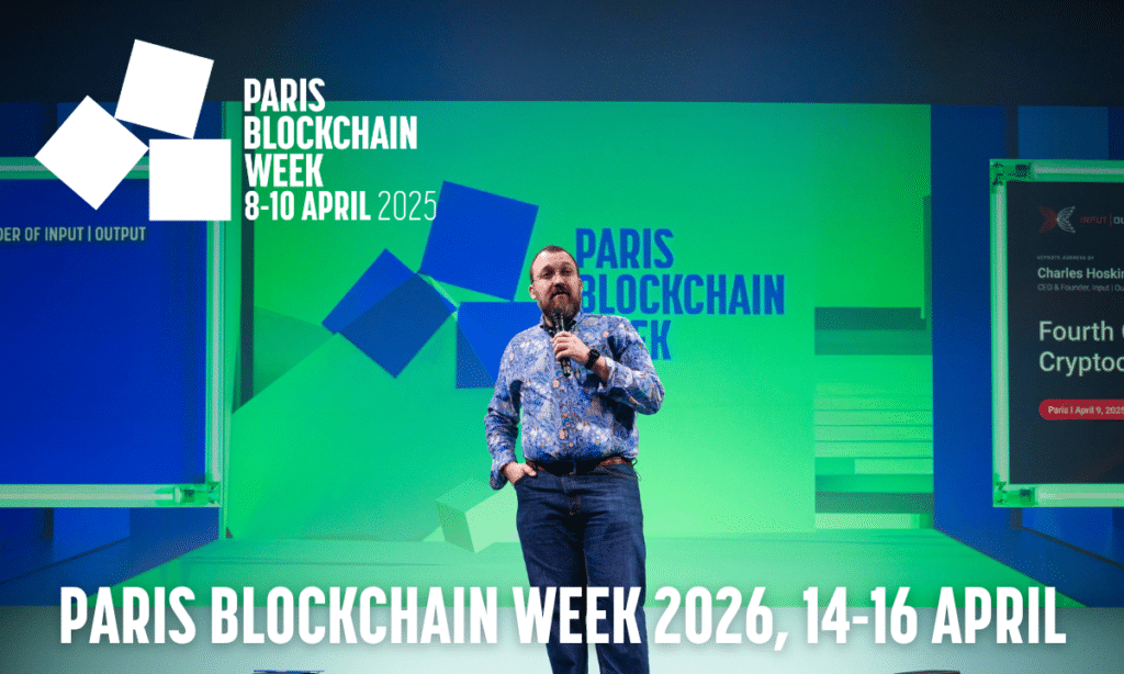 Charles Hoskinson stands on stage at Paris Blockchain Week 2025, with event details and branding displayed on a vibrant digital background.